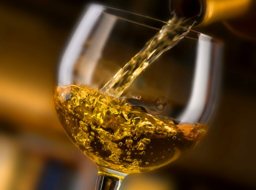 Un service de vin blanc de la bouteille dans un verre à pied
