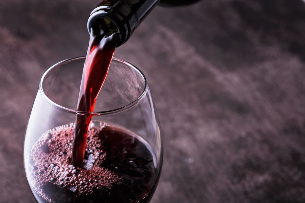 Un service de vin rouge de la bouteille dans un verre à pied